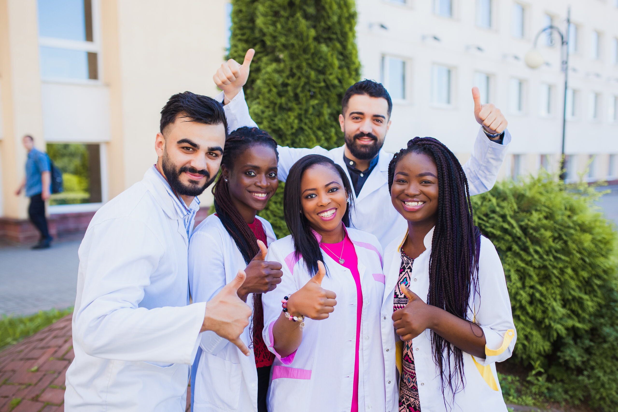 Group of cheerful African friends giving thumbs up. Happy interns physicians finish training