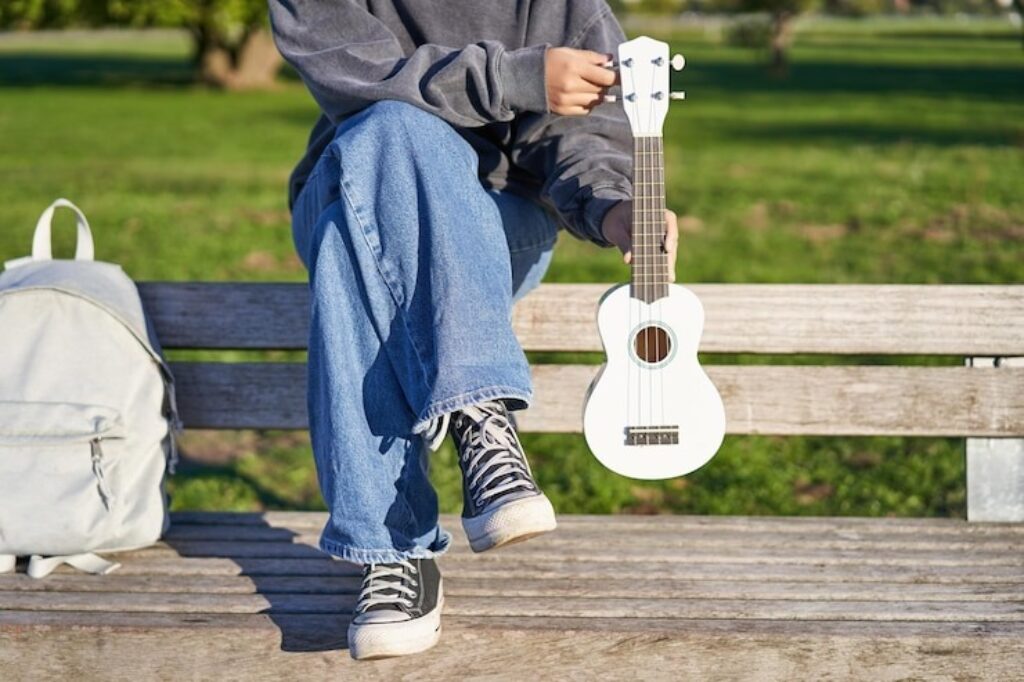 young girl play ukulele