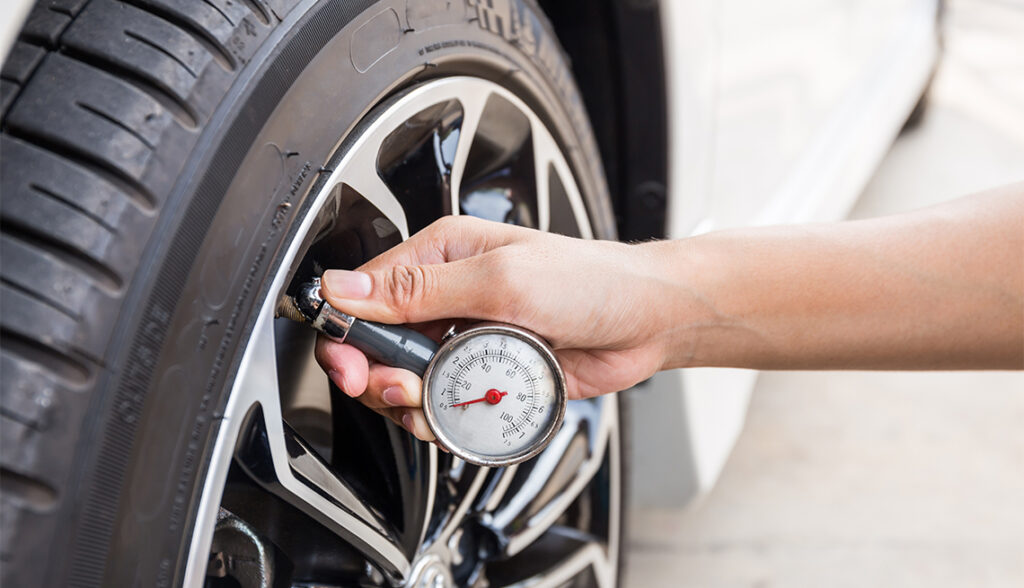 Close-Up Of Hand holding pressure gauge for car tyre