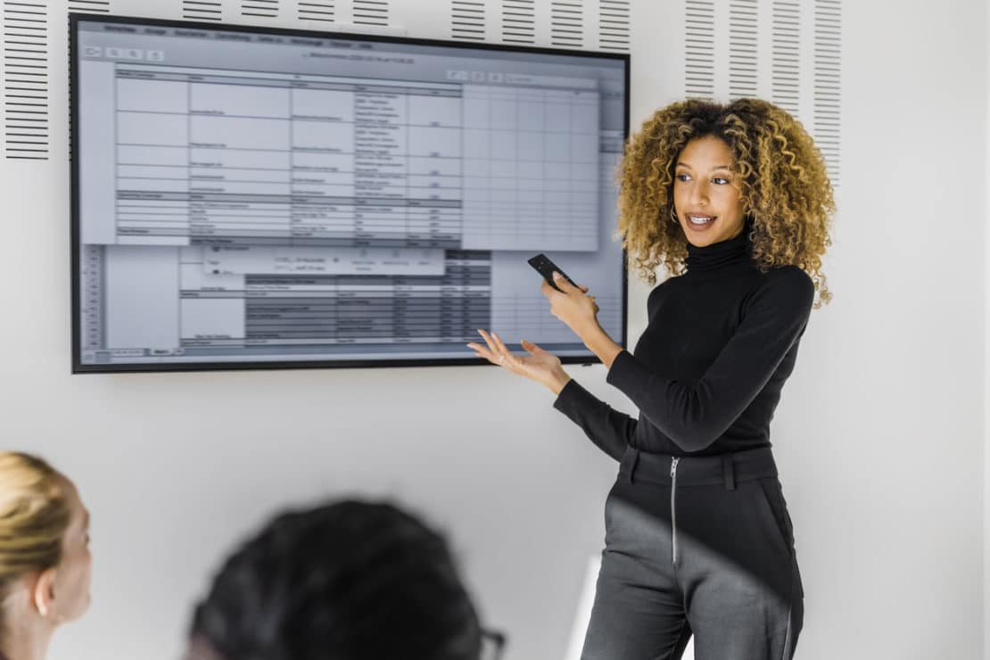 Female professional sharing new project details in team meeting