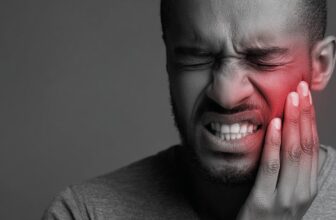 Man with a painful expression holding his cheek due to toothache