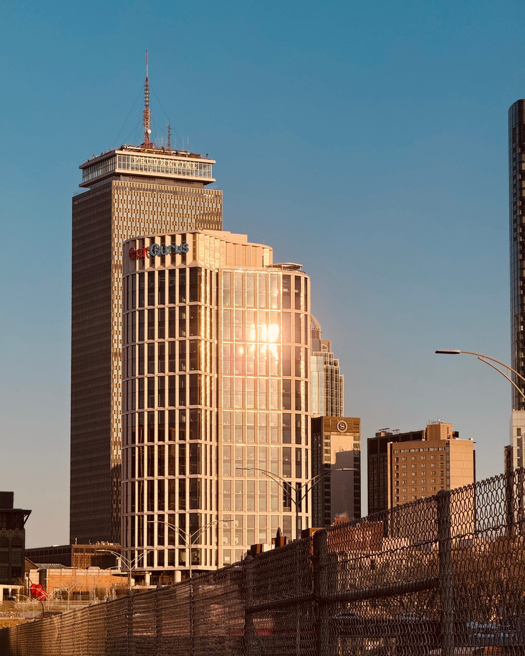 Boston skyline with skyscrapers and sunset reflections under a clear blue sky