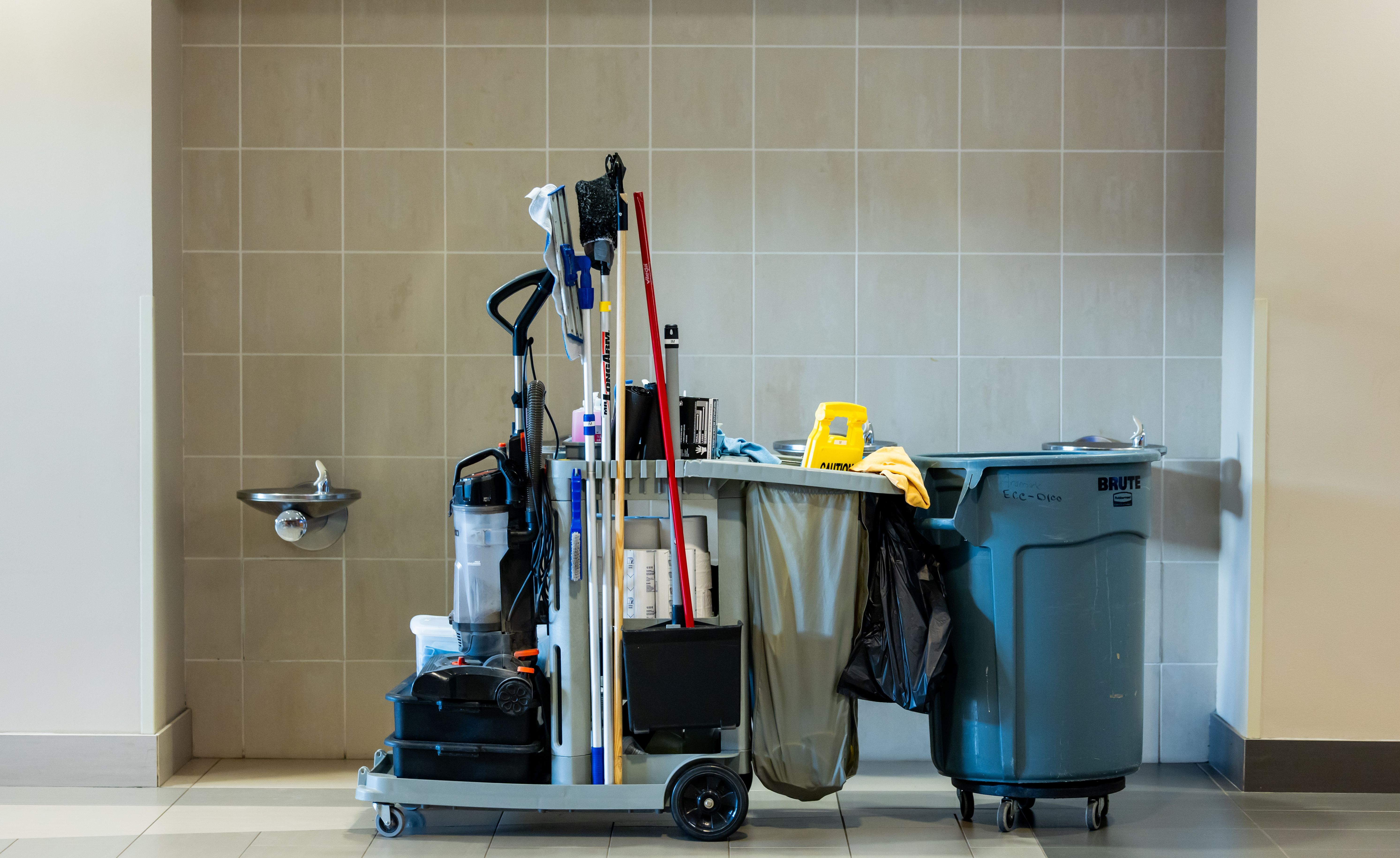 Professional cleaning tools and supplies organized on a cart in an indoor environment