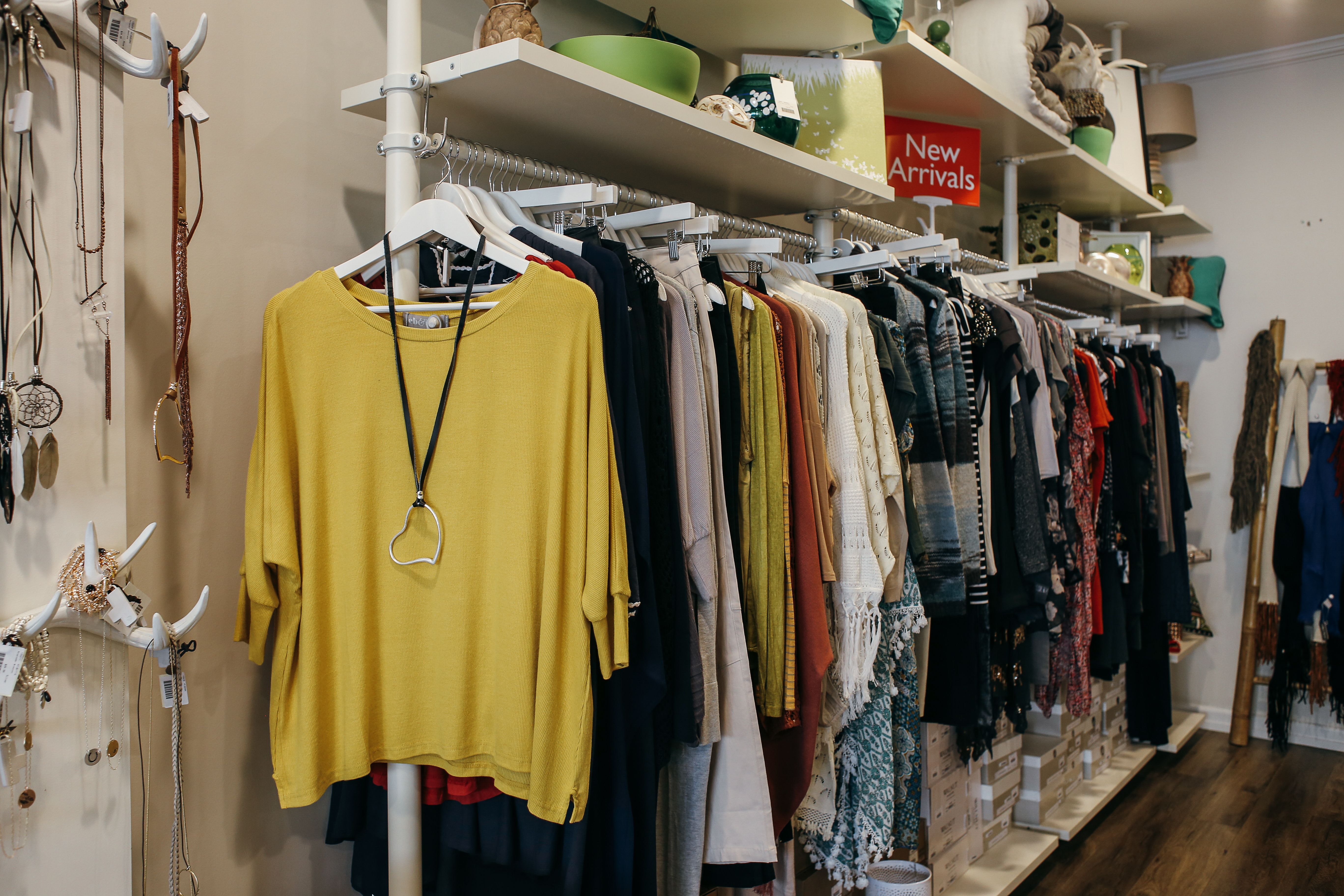 Interior of a fashion boutique with clothing elegantly displayed on racks and shelves