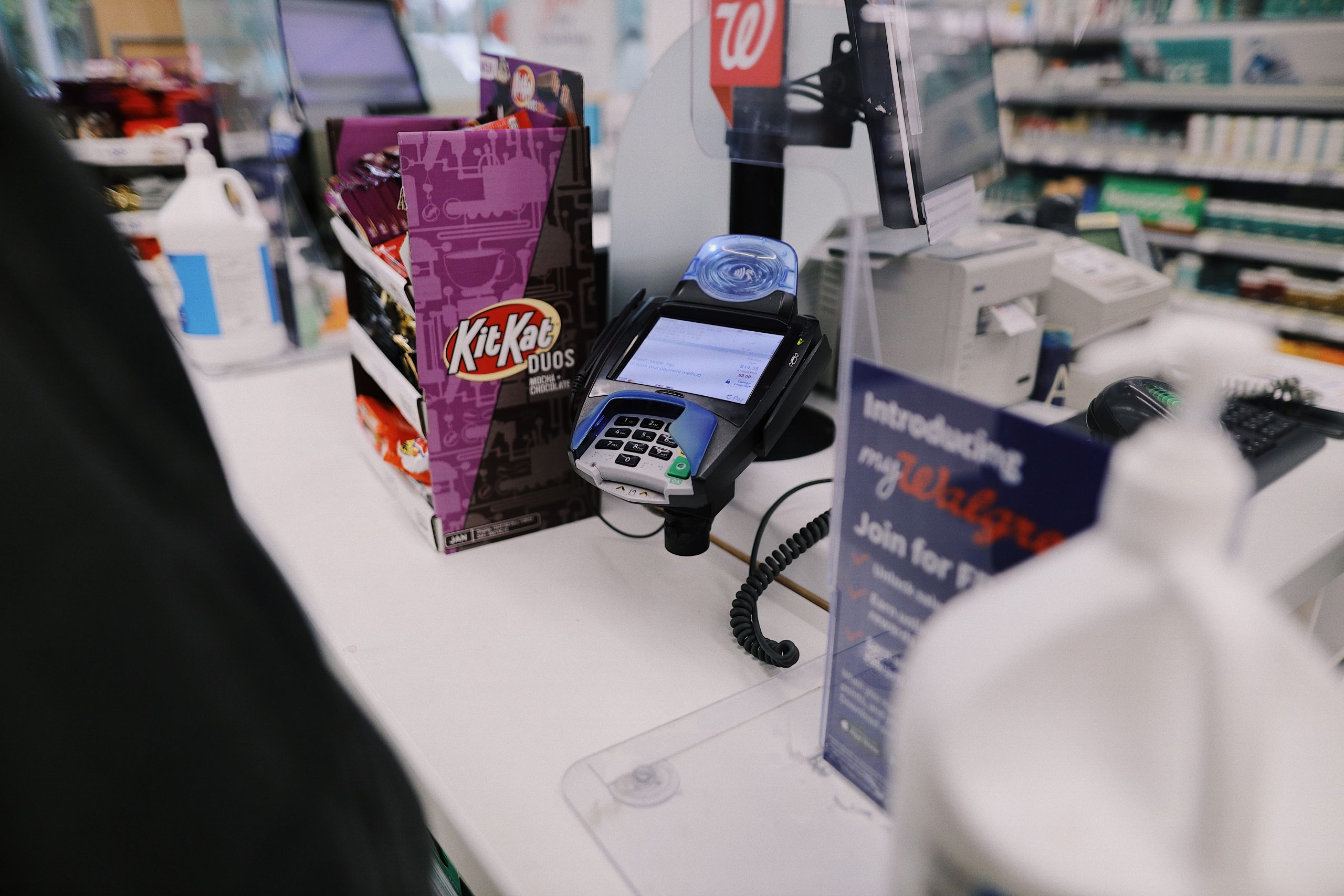 Retail checkout counter with a card reader and small goods arranged for sale at the point of purchase