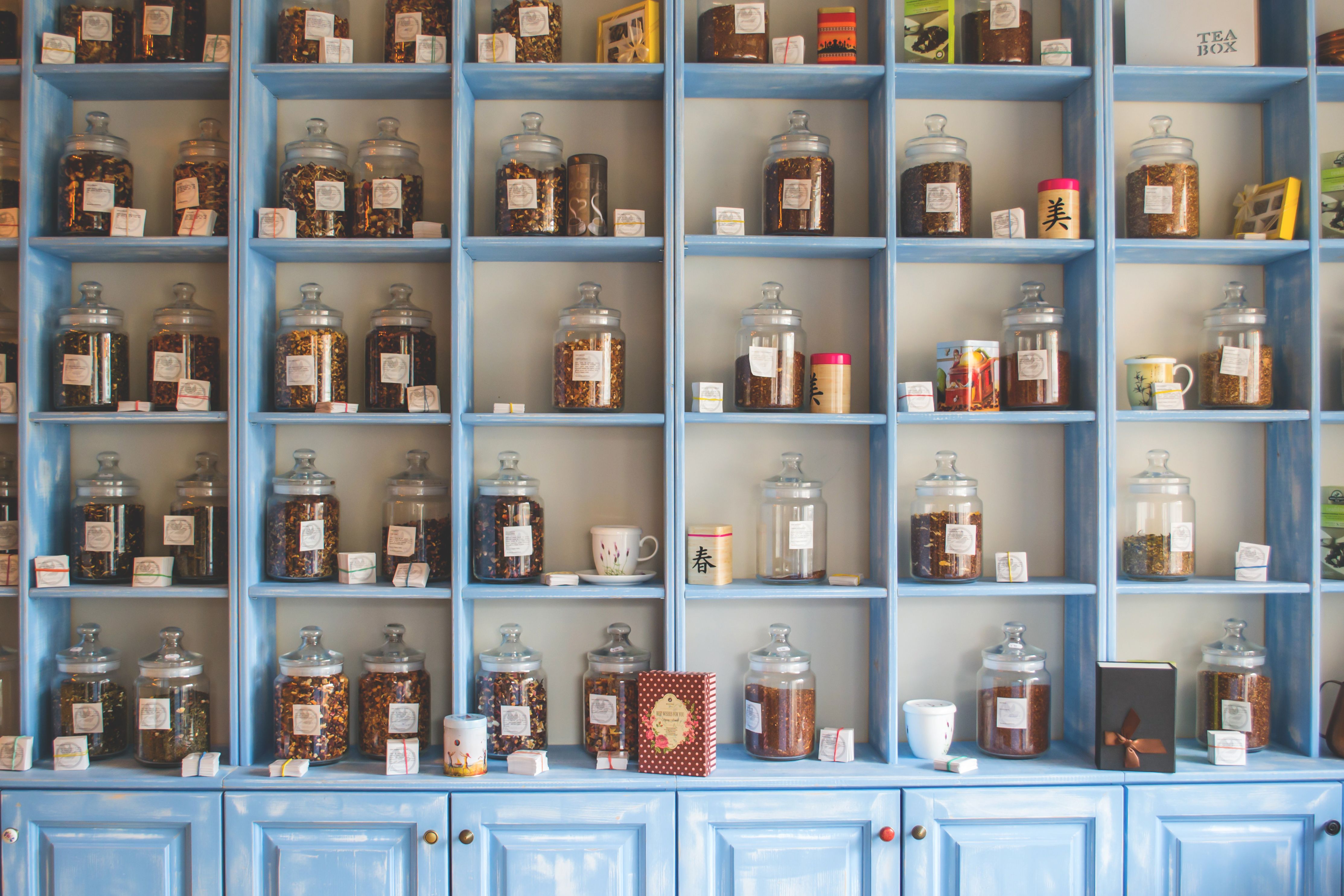 Organized product display of jars on colorful shelving in a retail shop